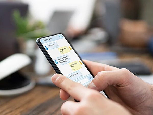 Person holding a phone while viewing a chat conversation.