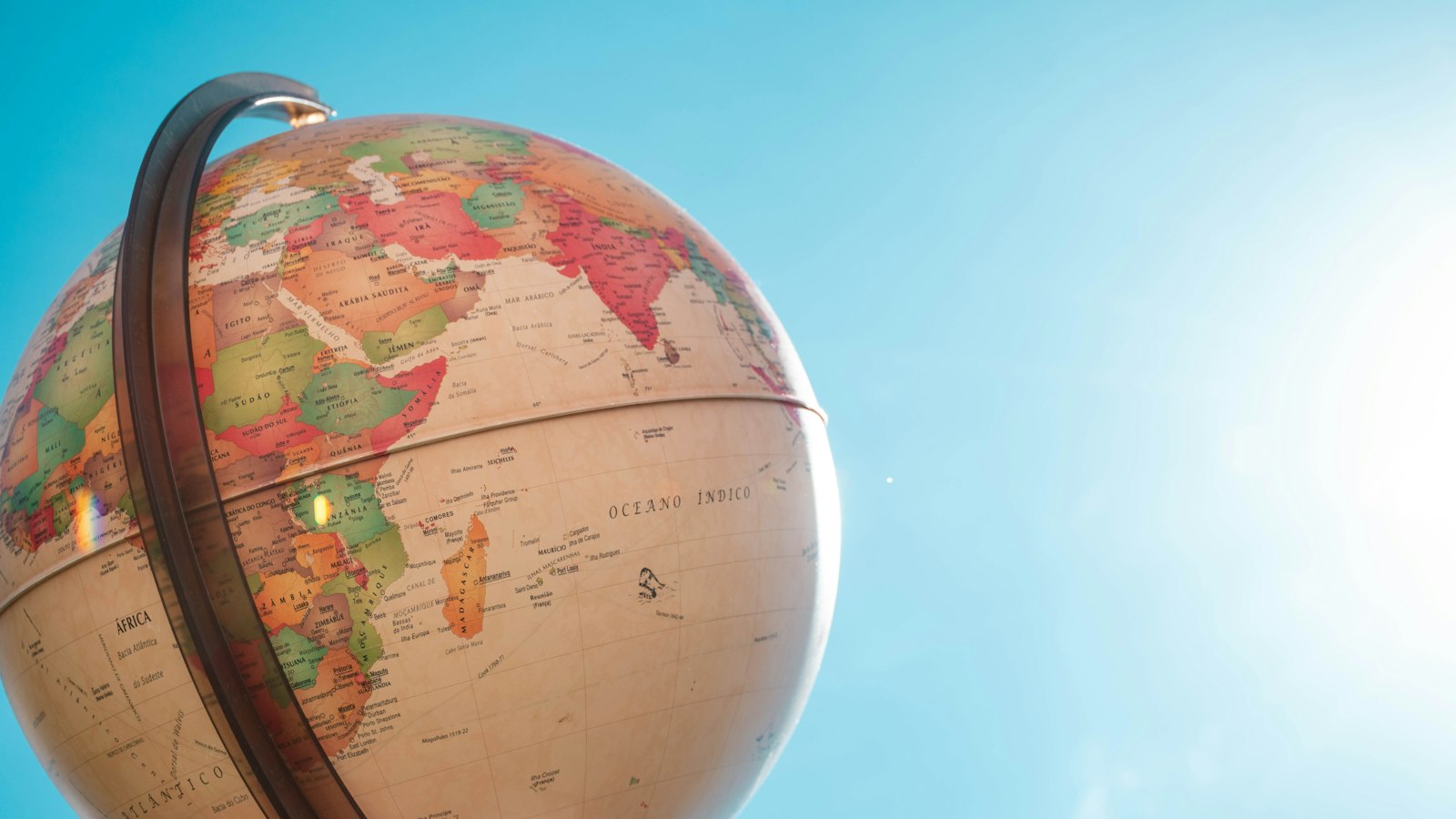 Warm-toned desk globe showing Africa and the Indian Ocean against a bright blue sky