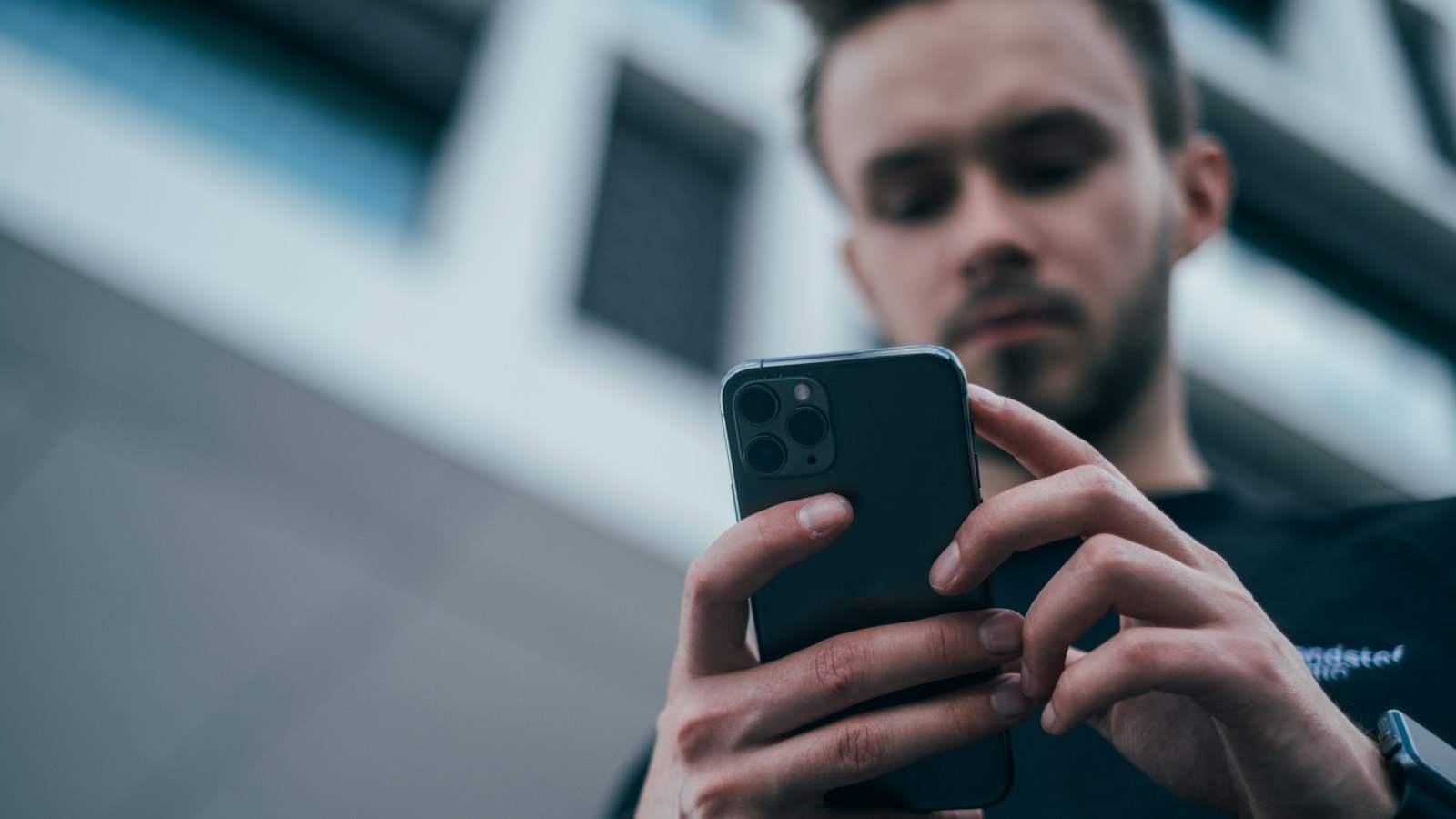 Business professional using a smartphone to represent a branded alphanumeric sender ID